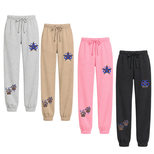 Four pairs of women's jogger sweatpants in heather gray, tan, pink, and black, each featuring a blue and purple skate graphic on the upper thigh and a matching graphic on the lower leg, SKATE 88 with Cheetah Star.