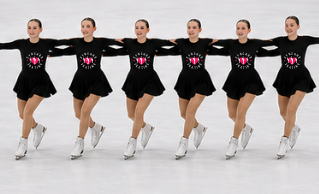 Group of figure skaters in black outfits with red heart designs on a white background